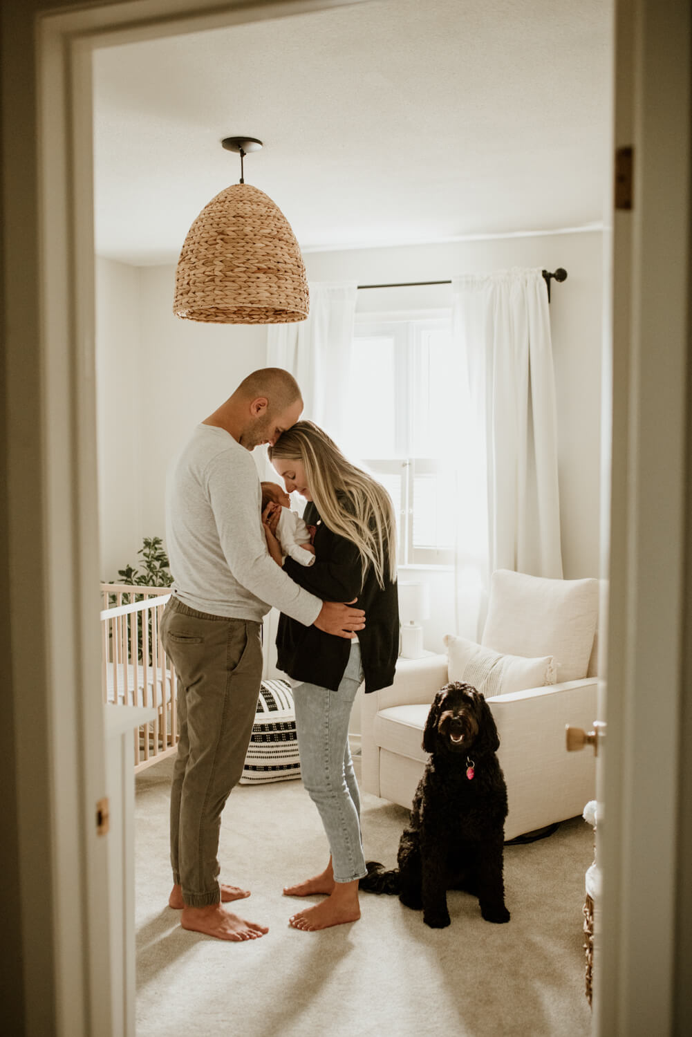 parents with baby and dog in the nursery