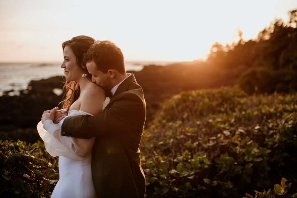 The groom kisses the bride's shoulder