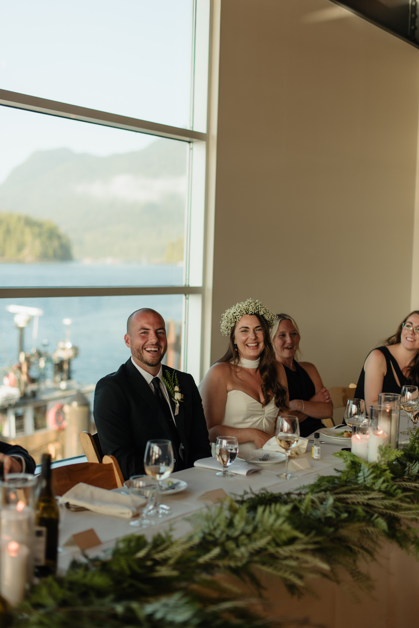 The bride and groom listen to speeches at the Shore Pier