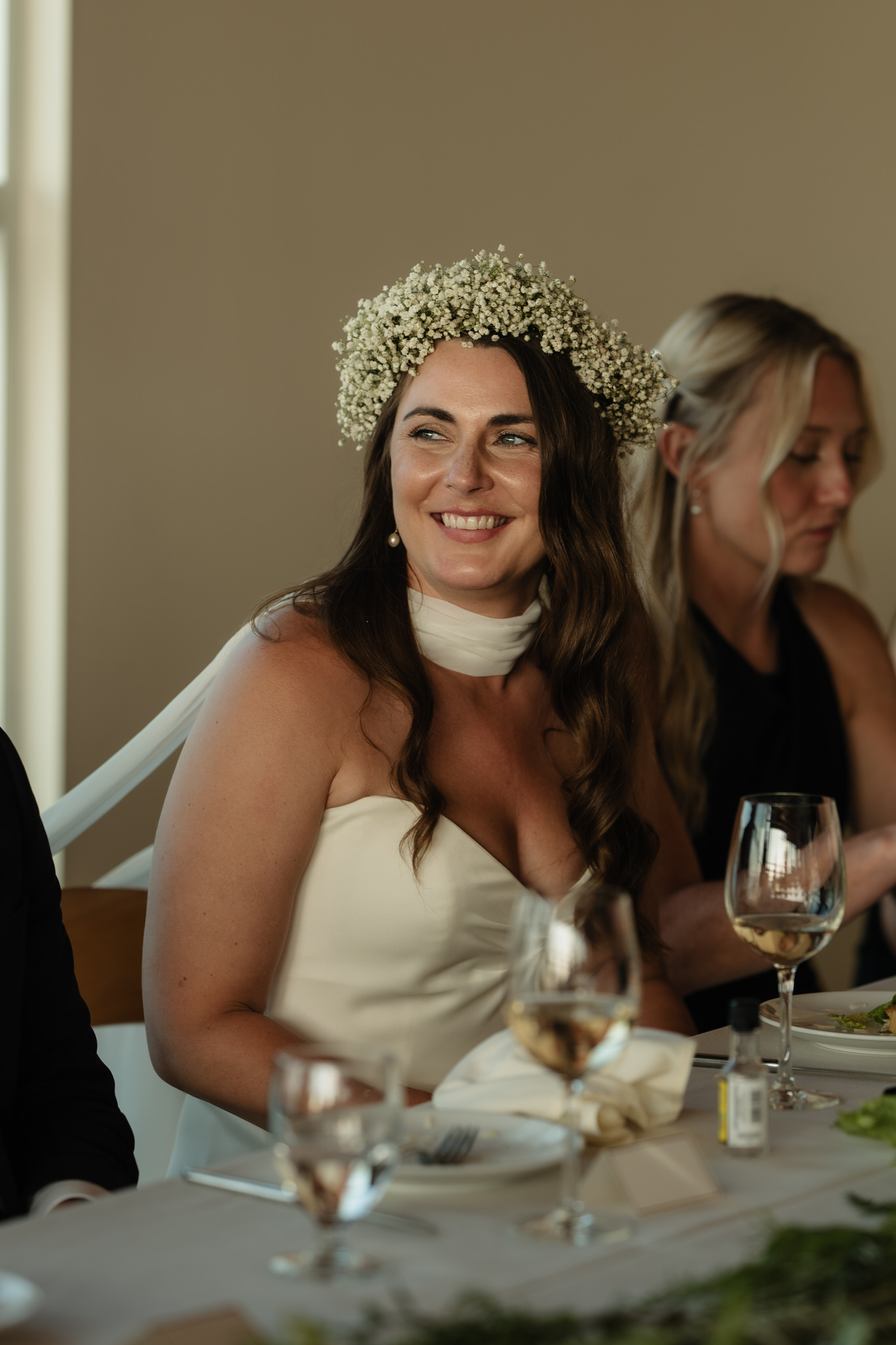 The bride and groom listen to speeches at the Shore Pier