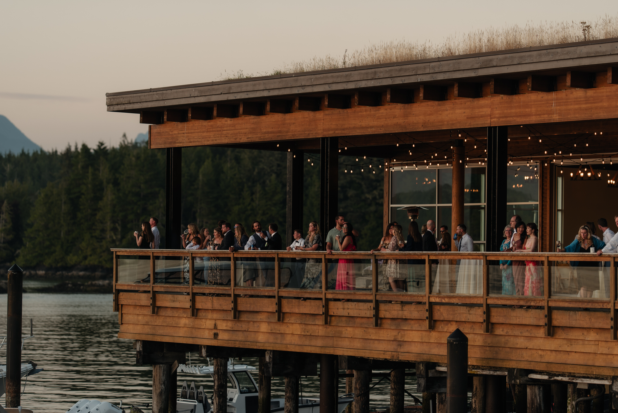 The Shore Pier wedding venue in Tofino as guests line up to watch the sunset