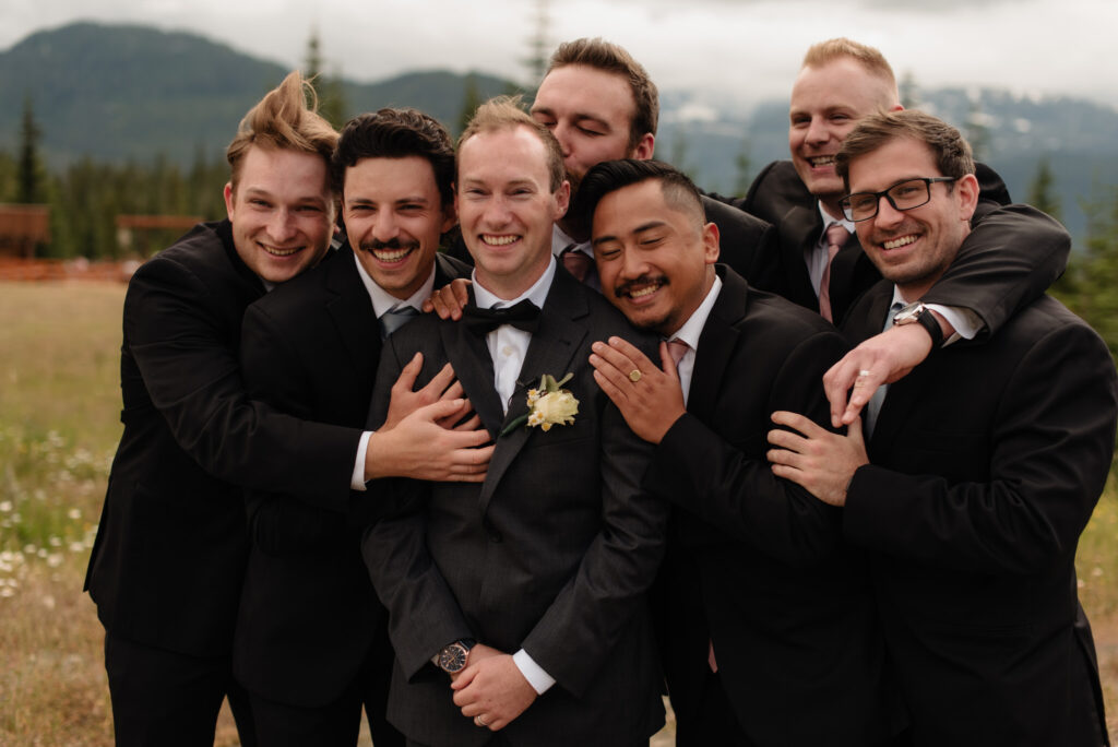 The groomsmen surround the groom with a hug
